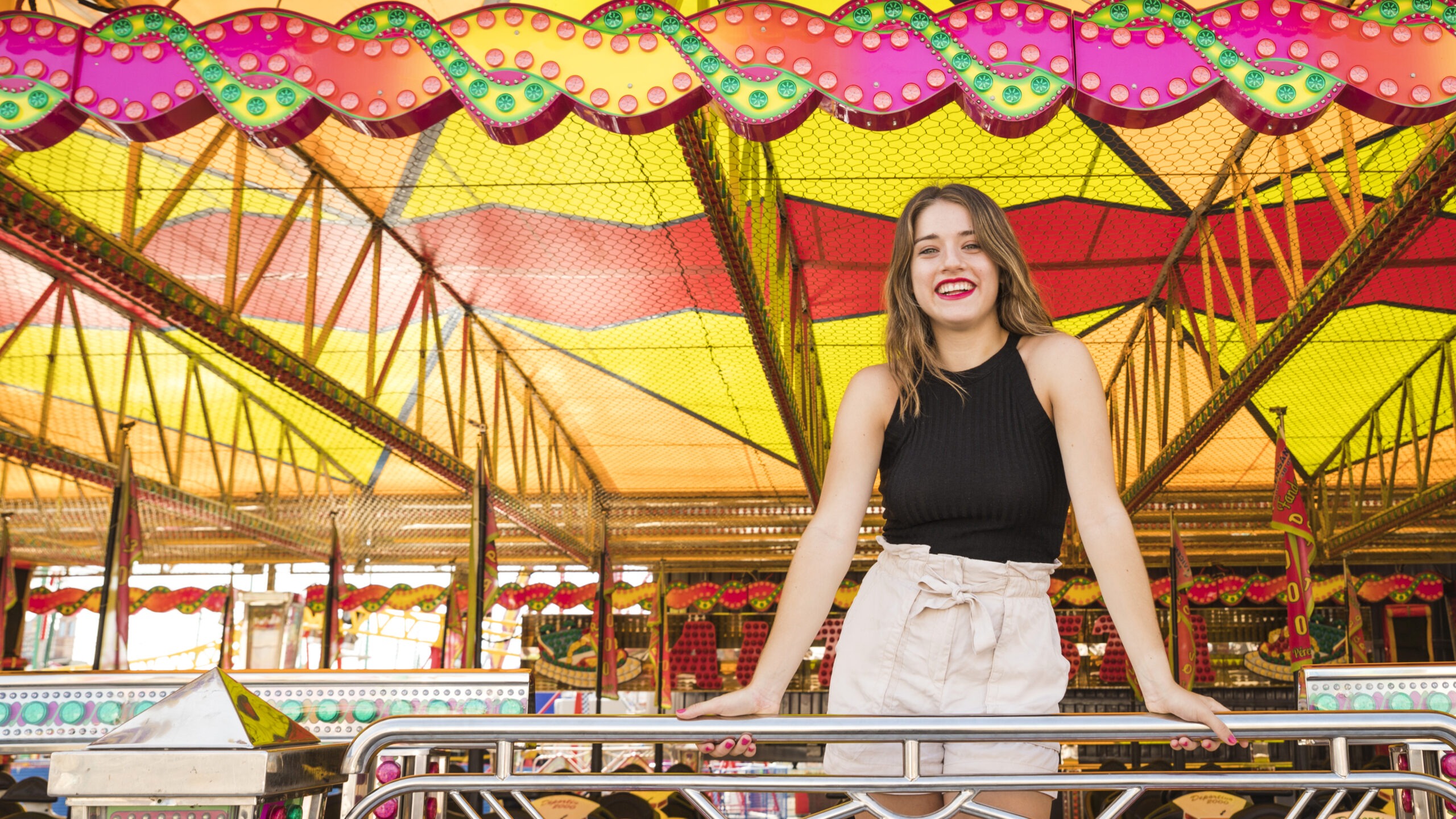 smiling young woman standing railing amusement park scaled Home